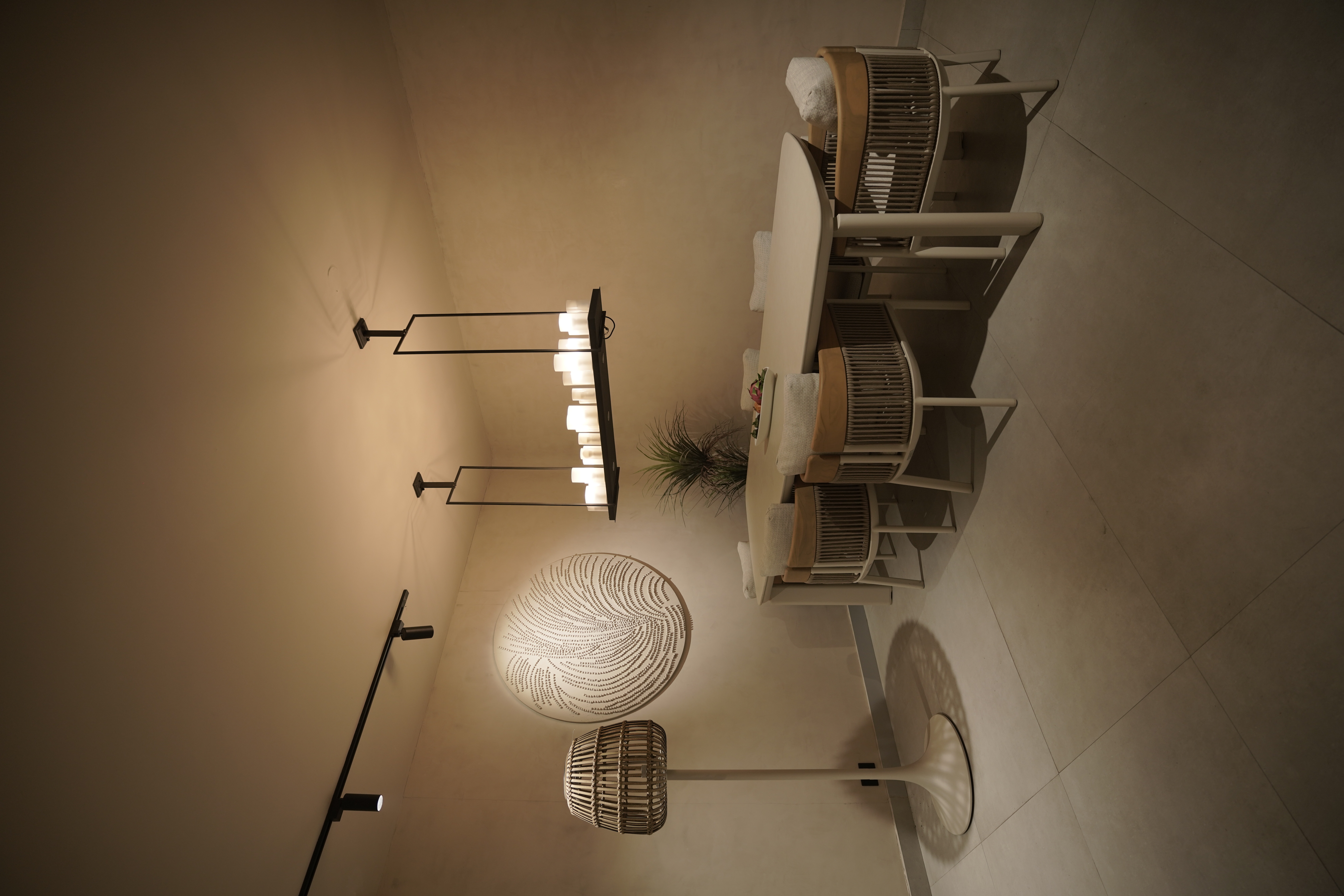 Minimalist luxury dining room interior by Shruti Chadha featuring sculptural pendant lighting, textured wall art, neutral palette, and handcrafted furniture in a contemporary Delhi home.