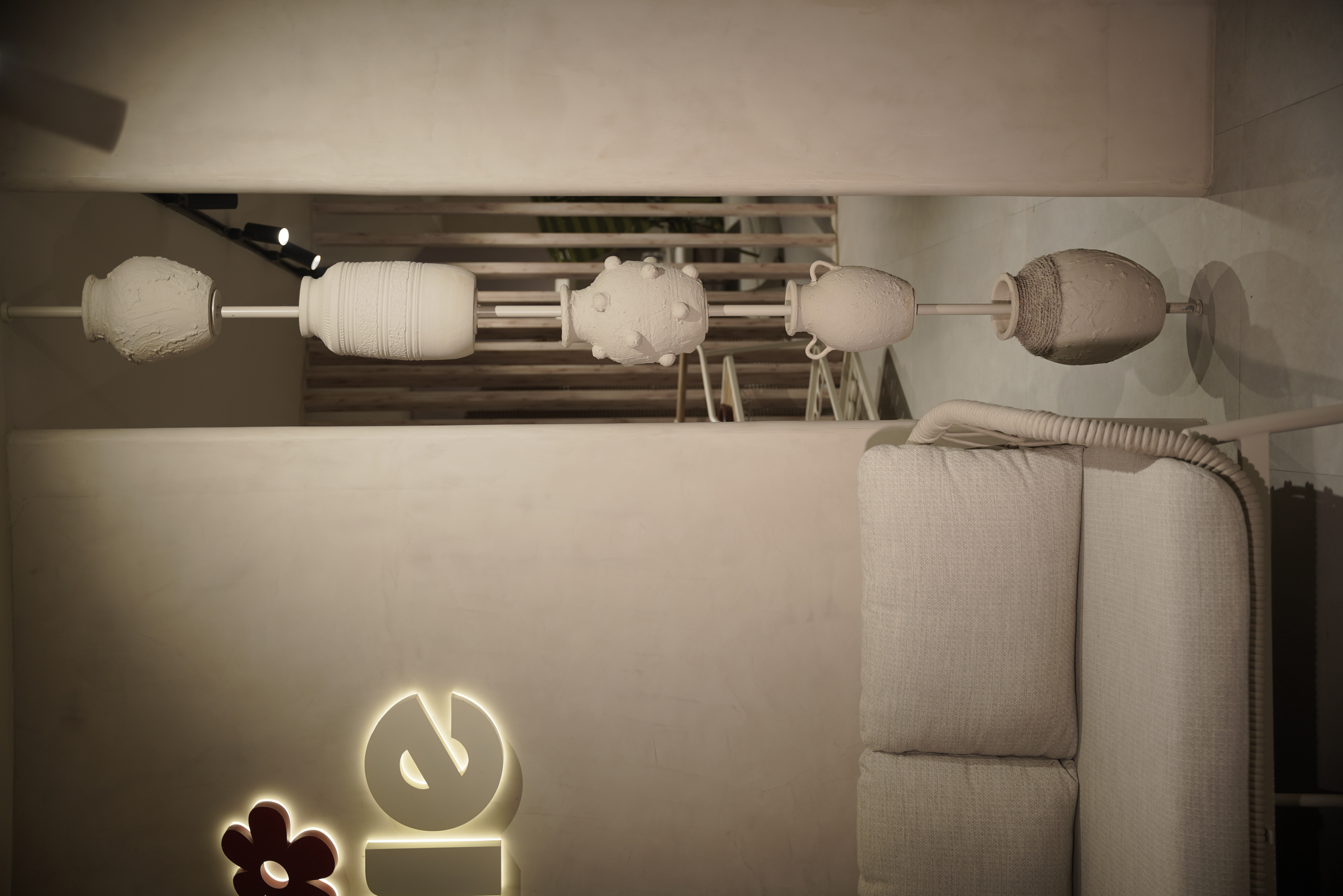 Artistic lighting installation in a luxury minimalist interior designed by Shruti Chadha, showcasing sculptural forms, soft illumination, and organic textures for a serene living space.